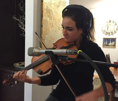 Violinist recording overdubs in the studio
