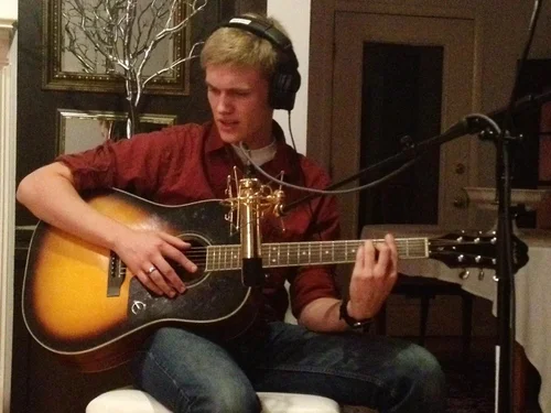 Guitarist recording an acoustic guitar track