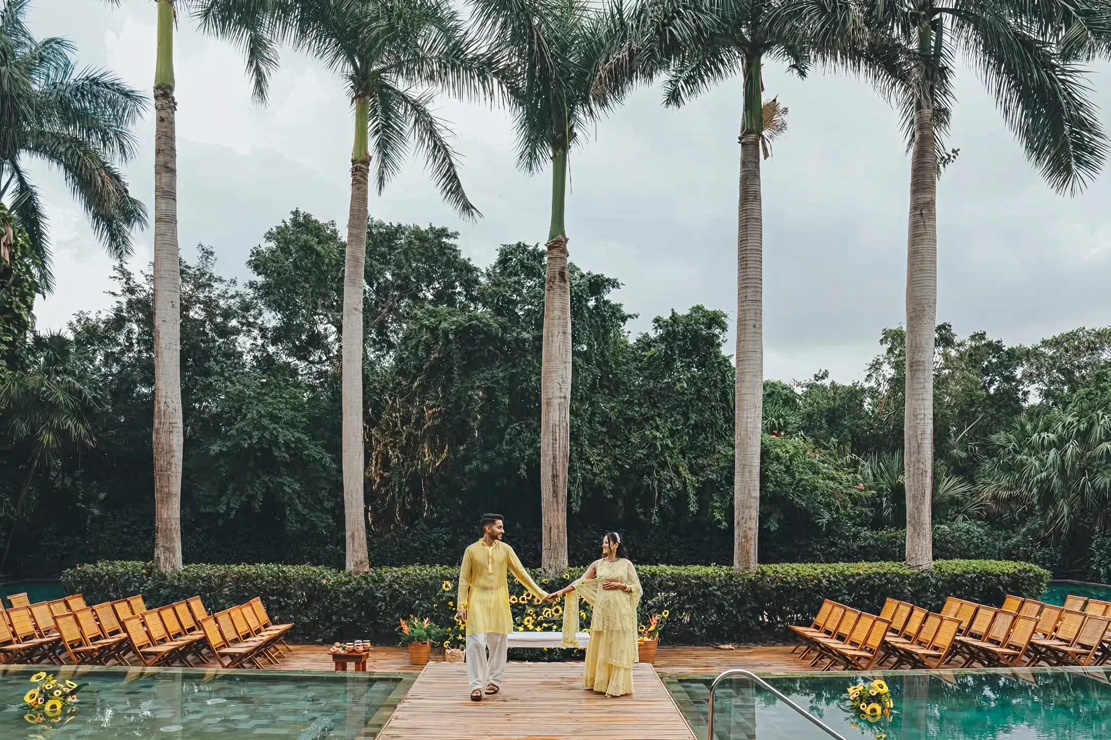 Couple walking beside a pool with palm trees