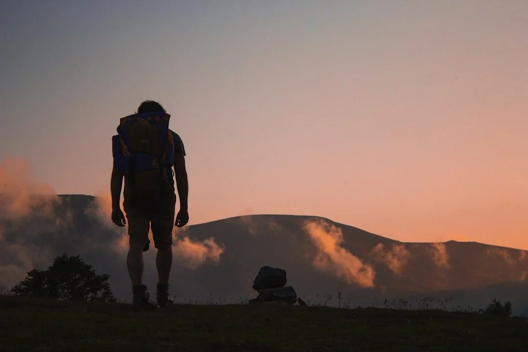 A backpacker looking over the mountains at sunset