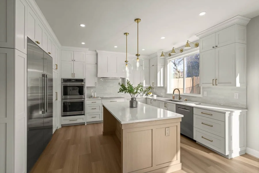 Luxury kitchen remodel by Massey Remodel + Design featuring Modern French country kitchen with white oak cabinetry, large island and plaster range hood