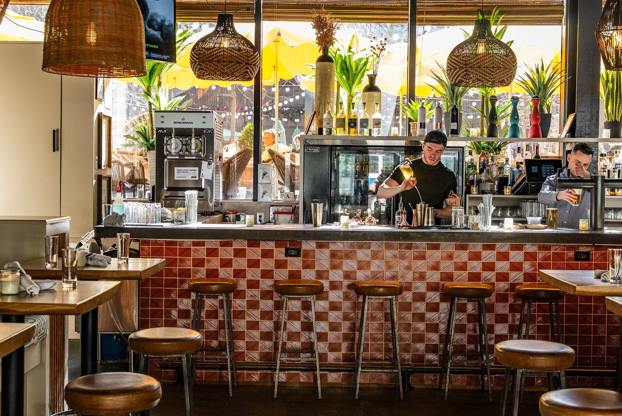 Indoor bar with two bartenders working on drinks at Avenida near Penn Station