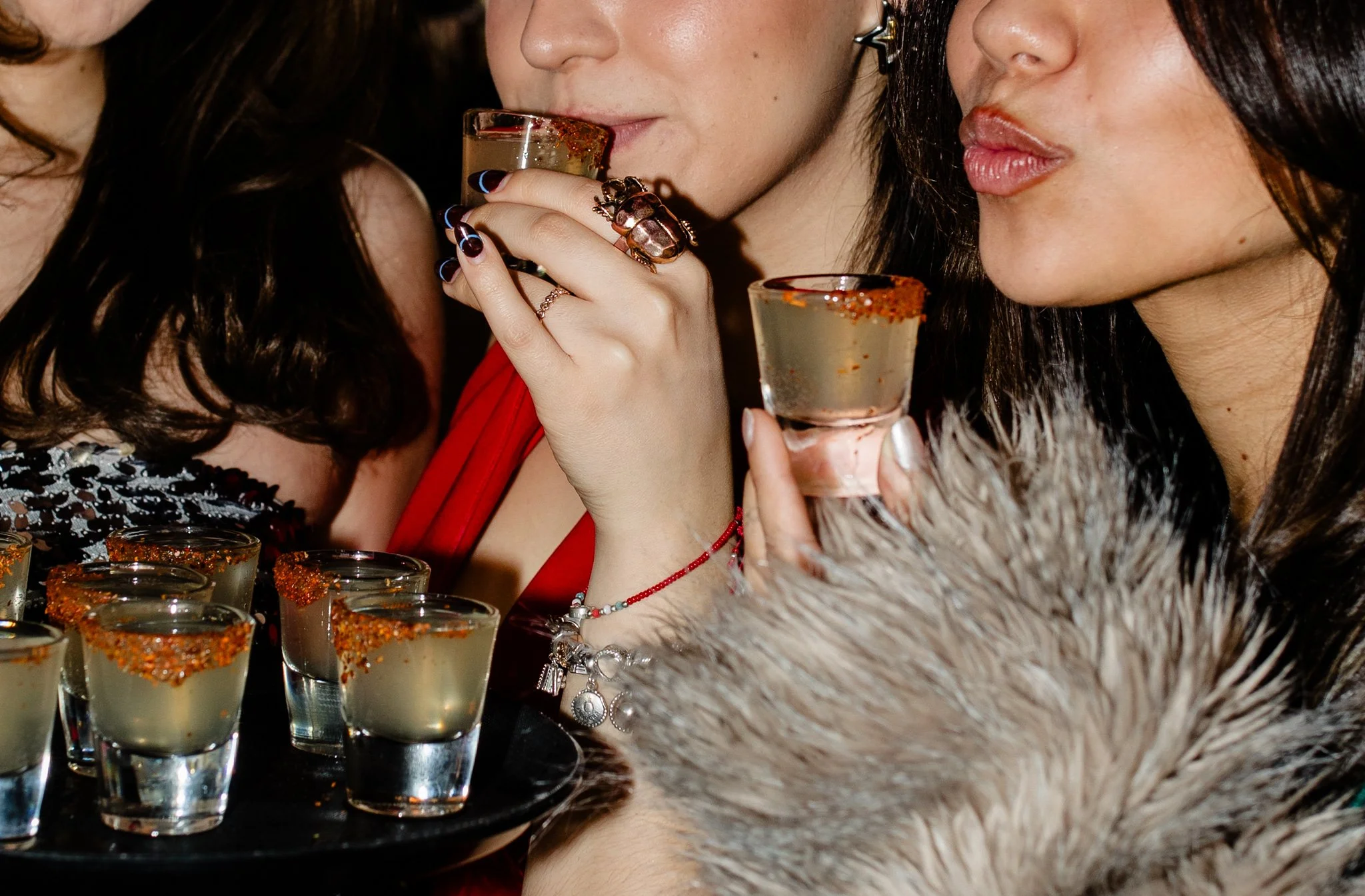 Three girls taking drinking a tray of shots with Tajin rims at Avenida