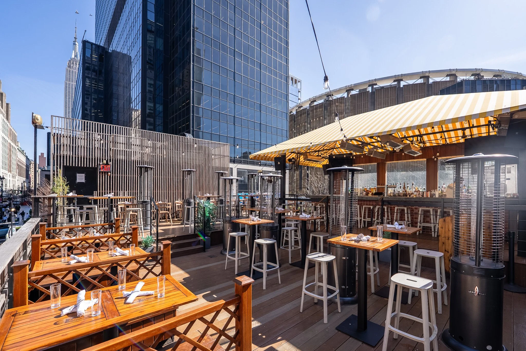 Rooftop seating area and shaded bar at Avenida with MSG in the background
