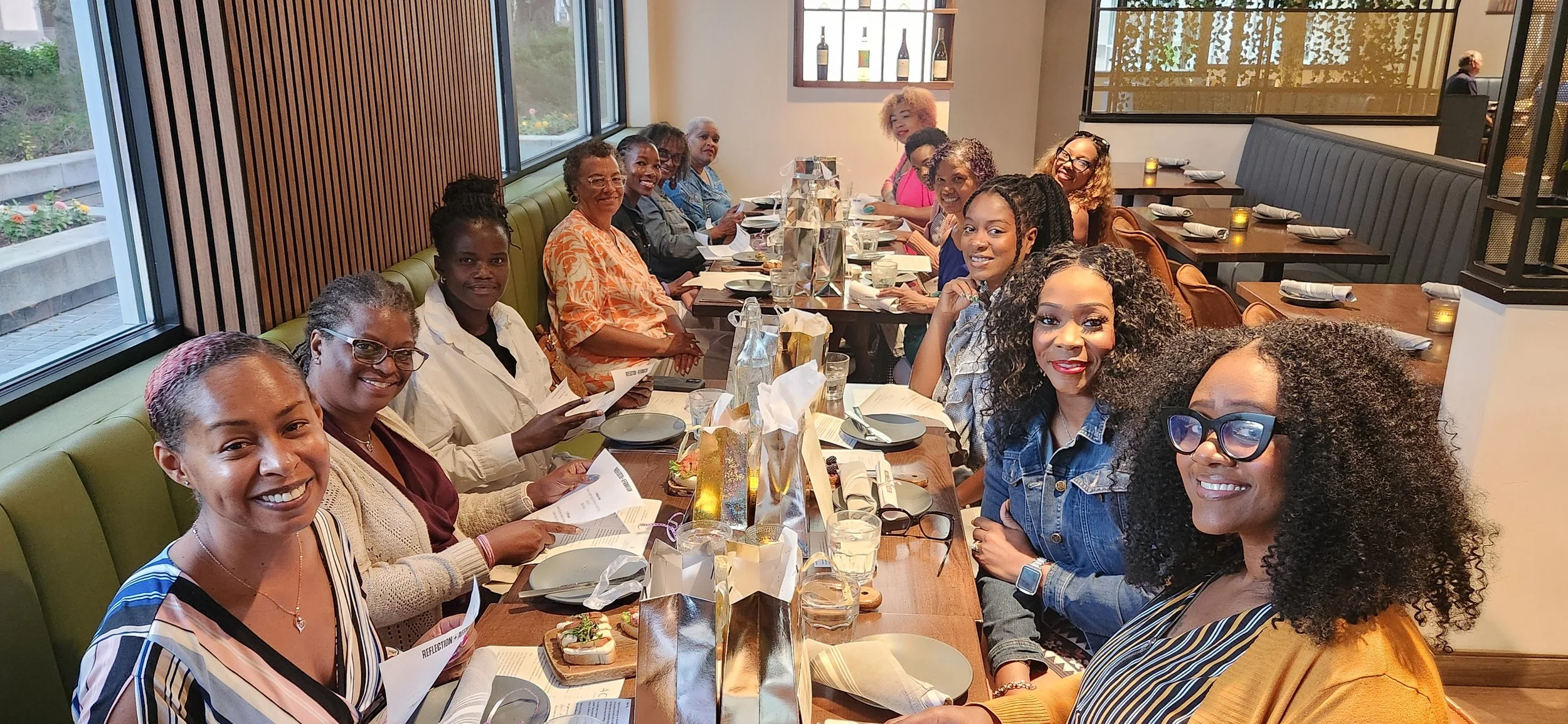 Black women gathered around a table at a Sistas Who Lunch monthly gathering in Boise, Idaho