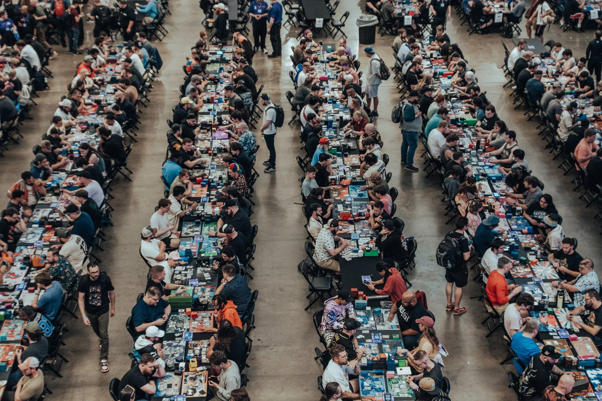 An overhead view of players at rows of tables in a card tournament
