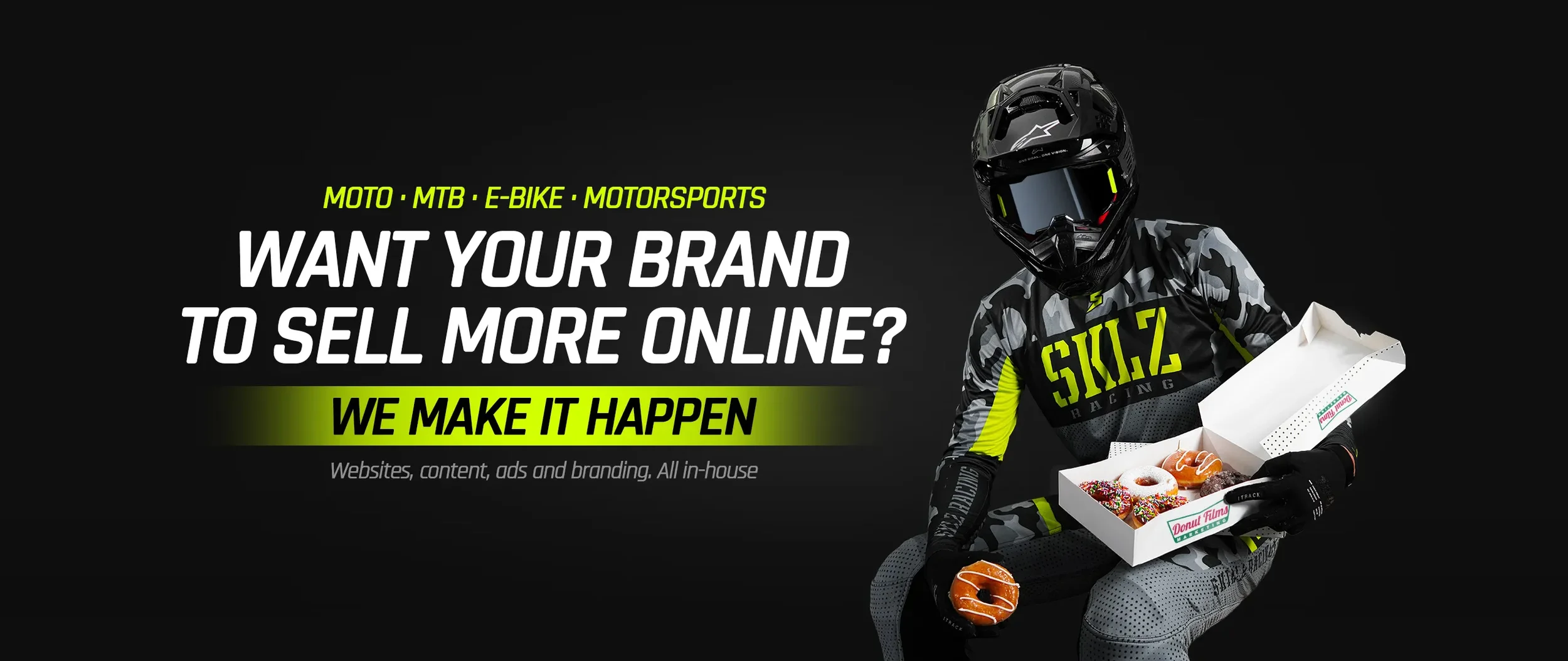 Rider in Skillz Racing gear holding a box of Donut Films donuts, motorsports marketing agency