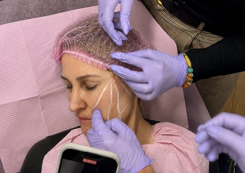 Student and trainer hands placing a cannula along the marked vector on a live model