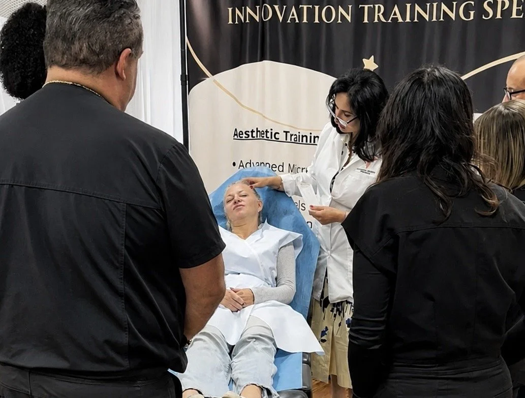 Trainer demonstrating facial anatomy on a live model with students around