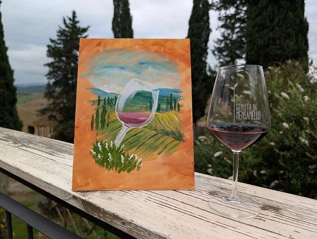 A painting and glass of wine overlooking the European countryside