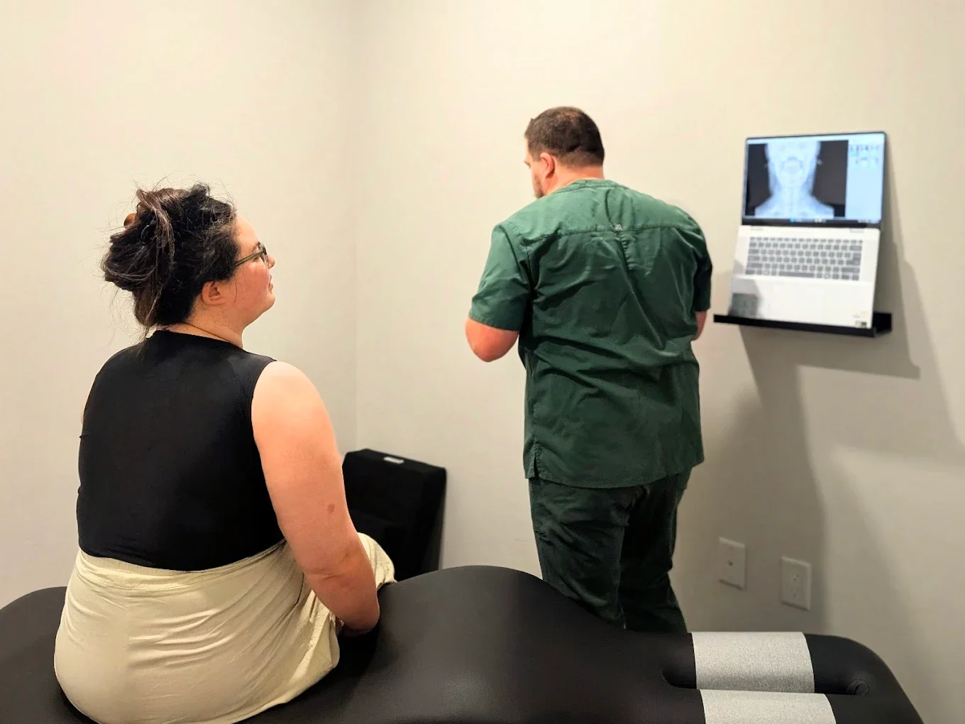 Doctor reviewing a neck x-ray with a patient to make a chiropractic diagnosis