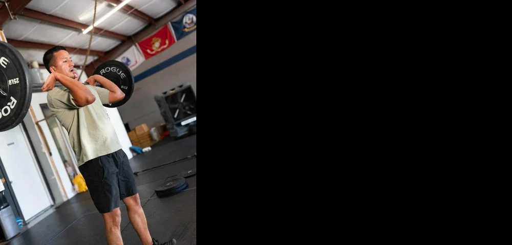 Member driving a barbell through a front rack lift at Einhorn Training Co.