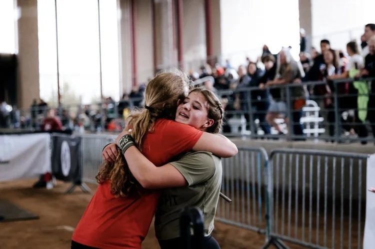 Two Einhorn athletes hugging at a fitness competition