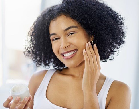 woman-smiling-with-one-hand-touching-her-face