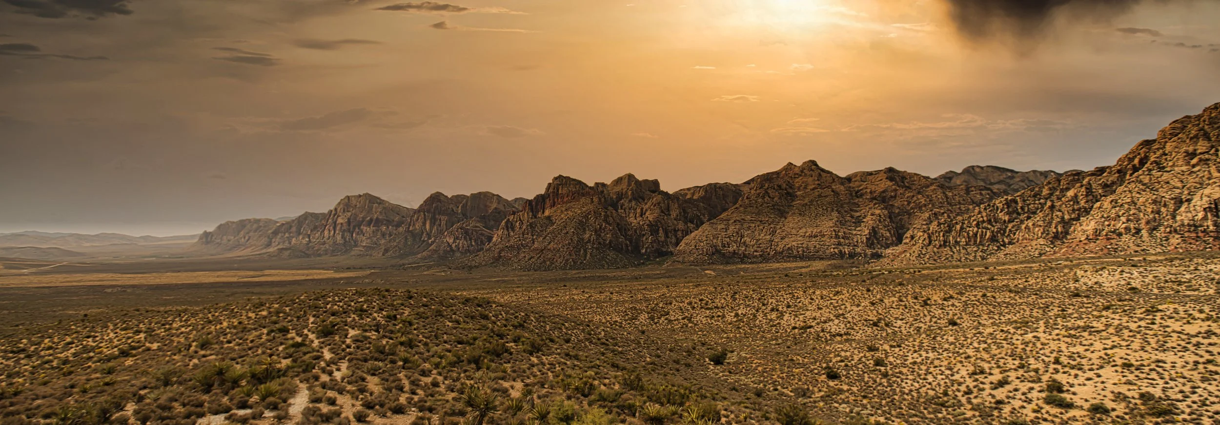 Sunlight across a broad desert mountain landscape