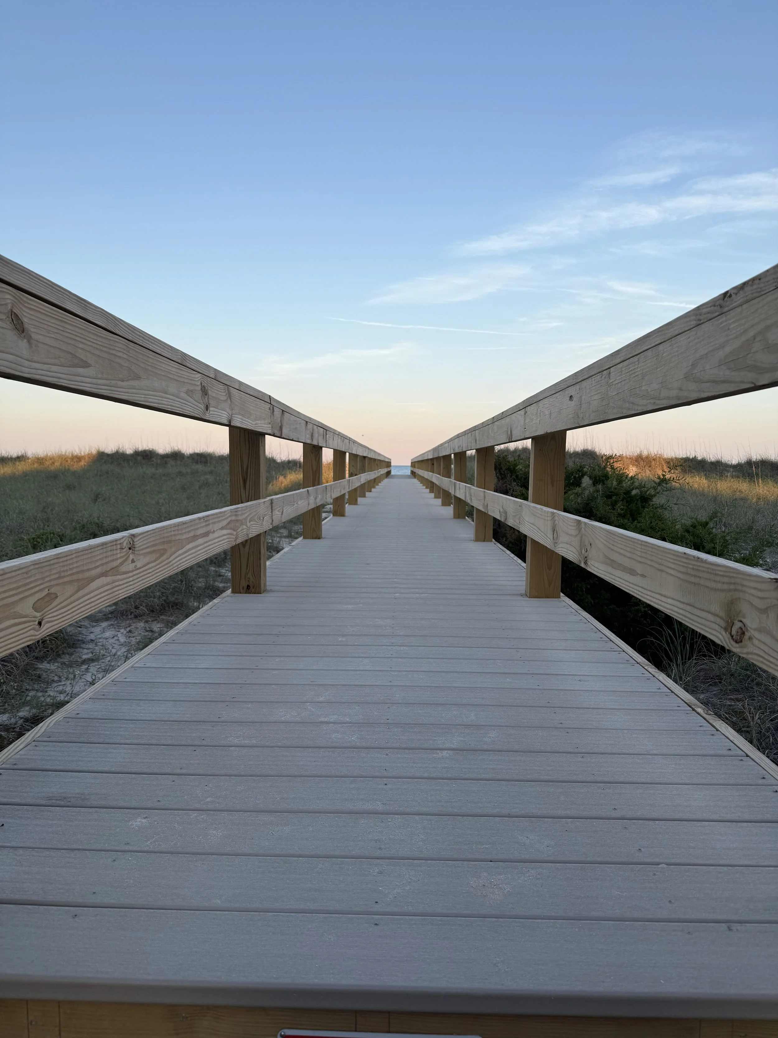 a wooden bridge oriented towards the ocean
