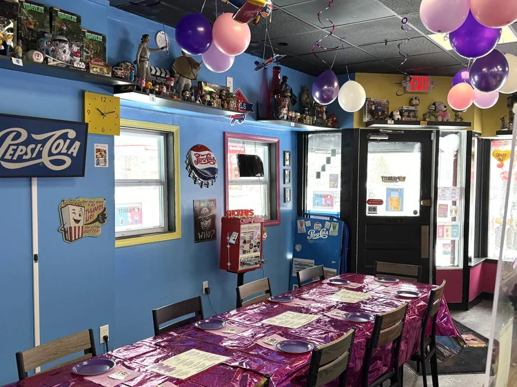 A party table set with menus and balloons for a birthday at POPularity!
