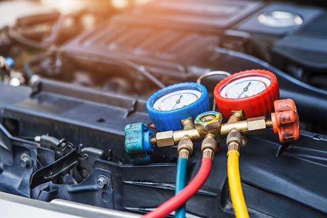 Technician connecting A/C gauges under the hood