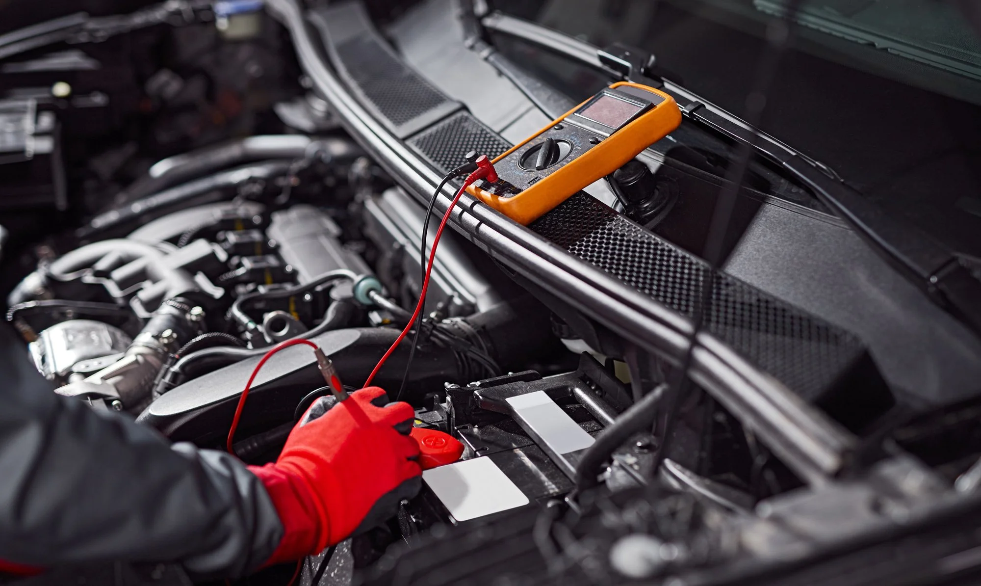 Technician testing a battery under the hood