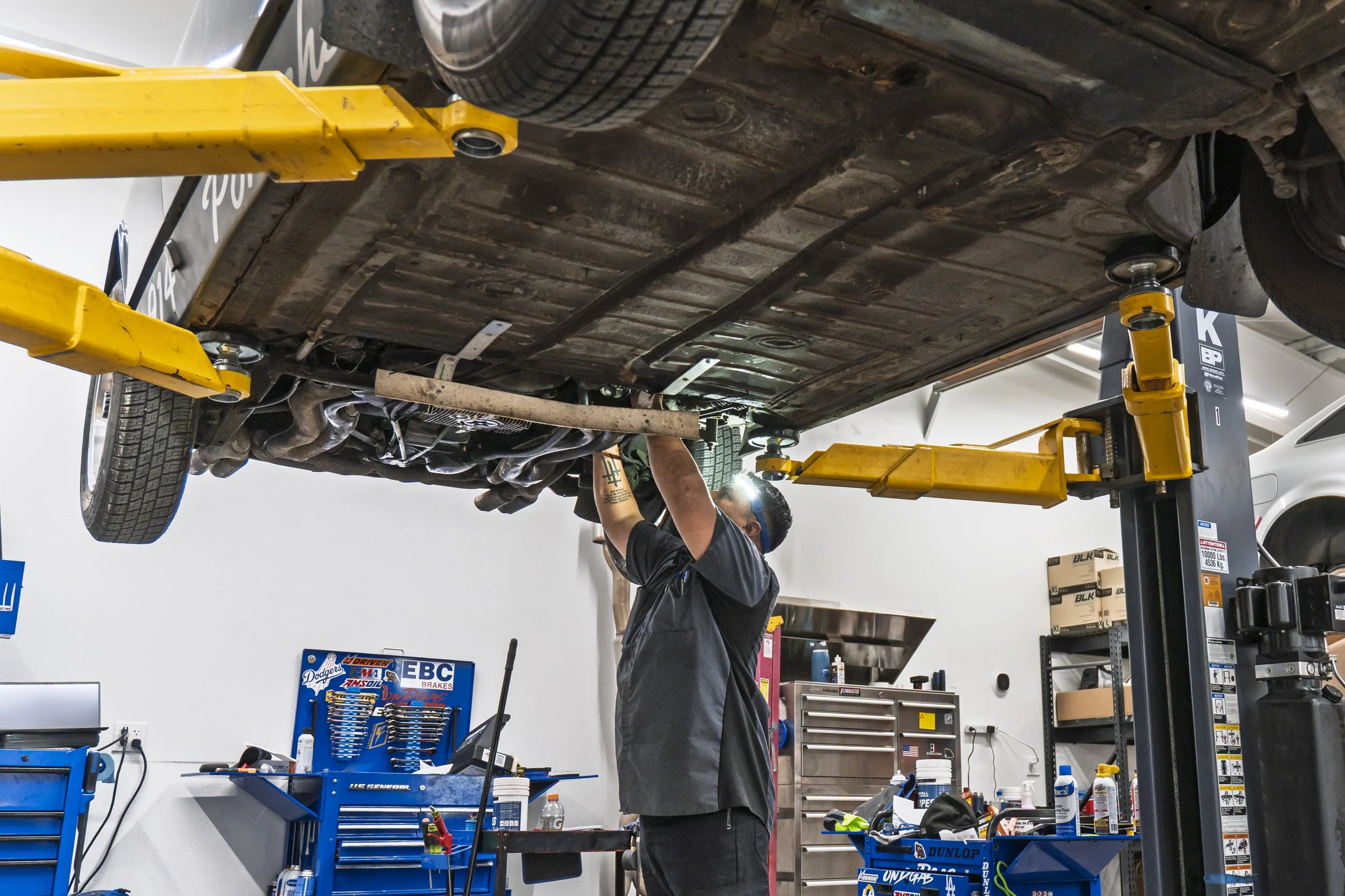 Technician working under a car on the lift