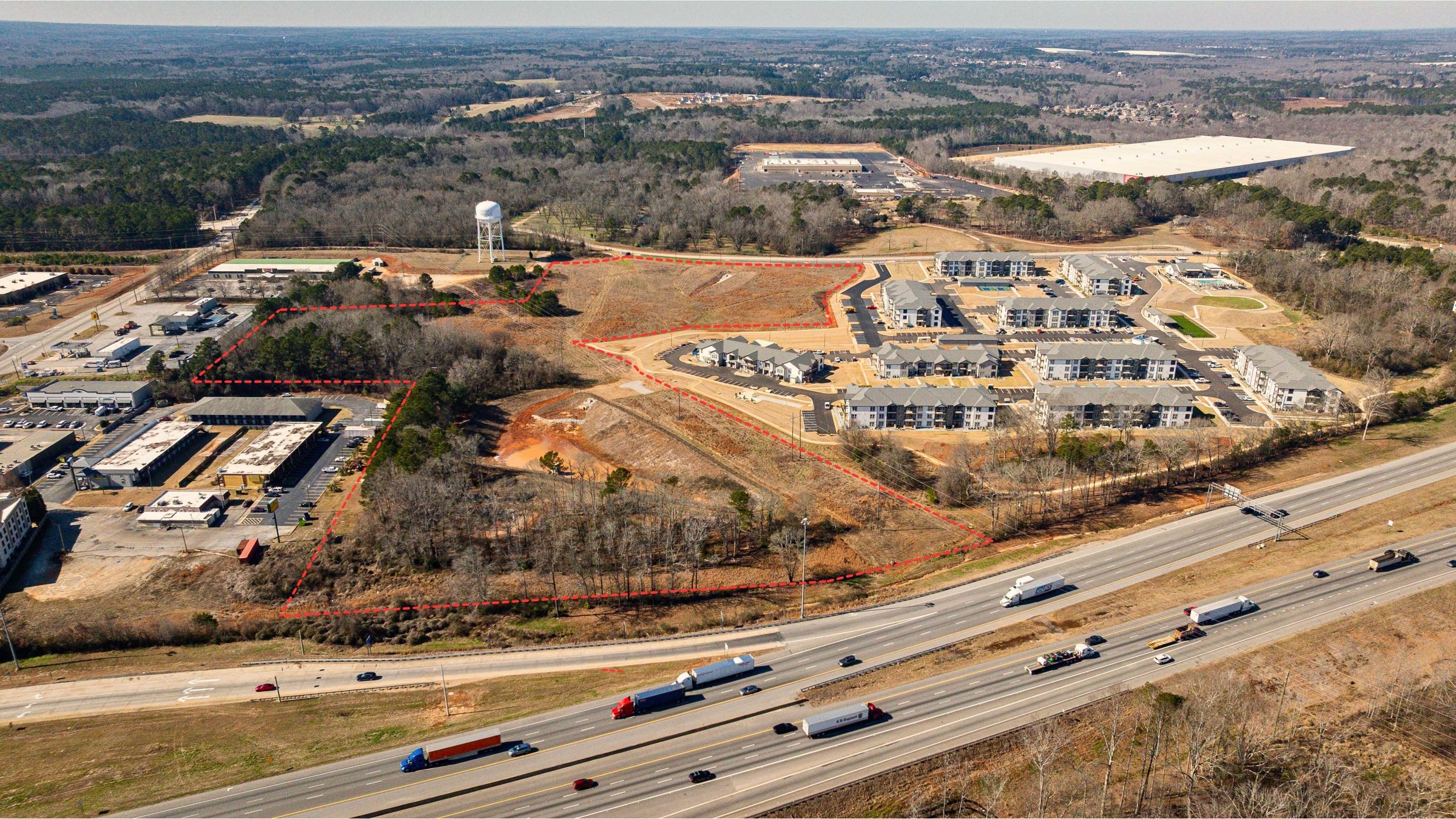 Commercial property with approximate property boundaries, adjacent apartments, and highway access.