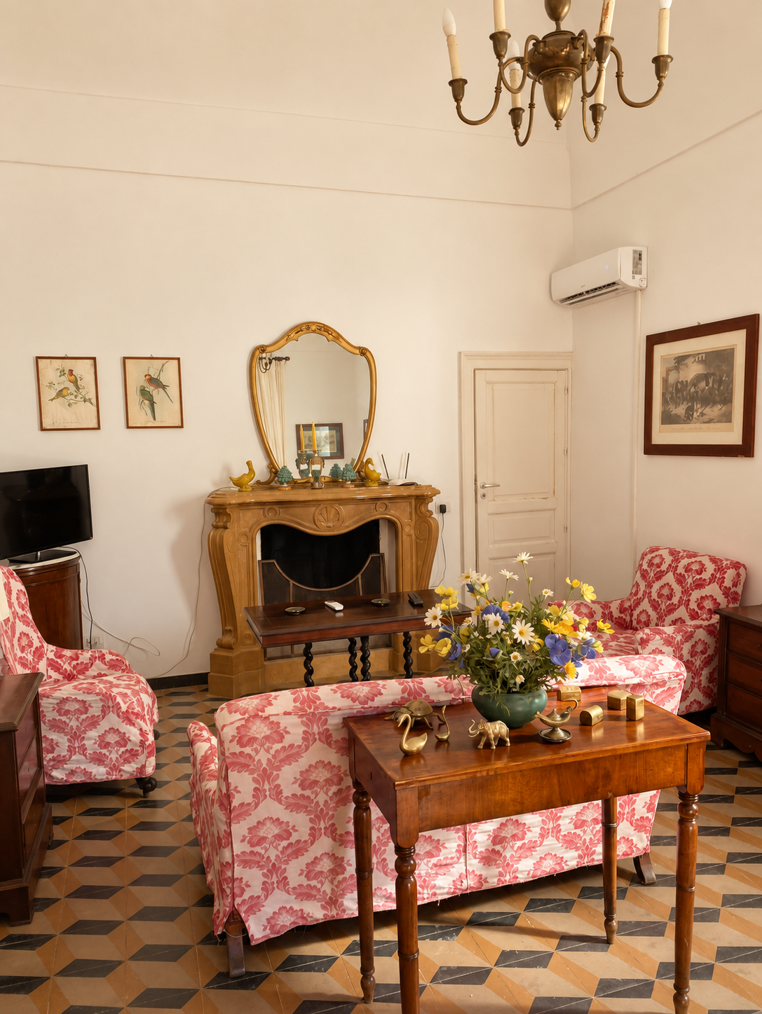 Shared living room with patterned pink sofas and a fireplace
