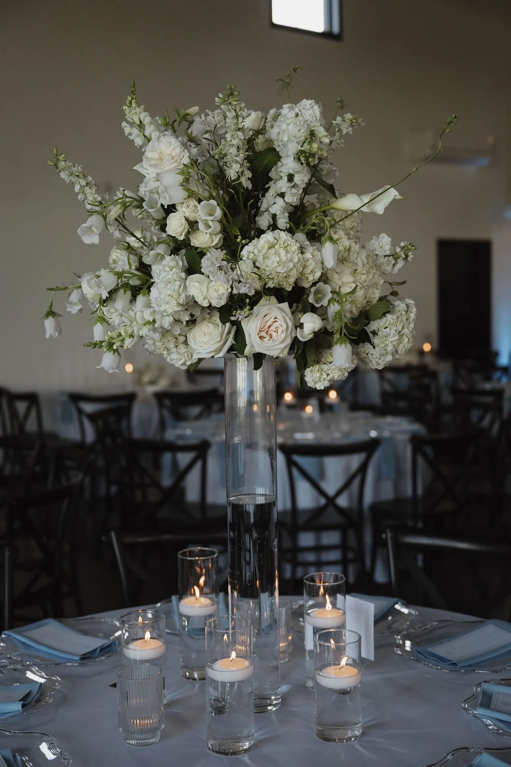Tall white centerpiece rising above candles at the reception, florals by Hydrangea Bloom, photographed by Shelby Sawyer Photography