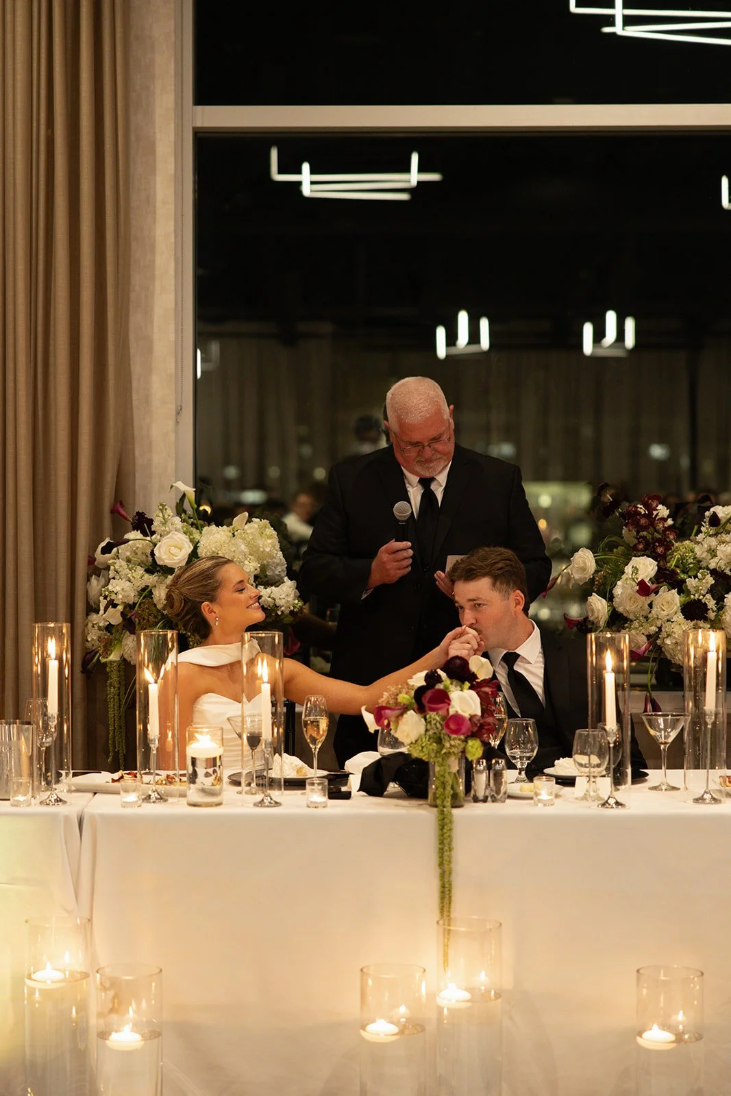 Head table arrangements in burgundy and ivory among candles, florals by Hydrangea Bloom, photographed by Madisen Timp Weddings