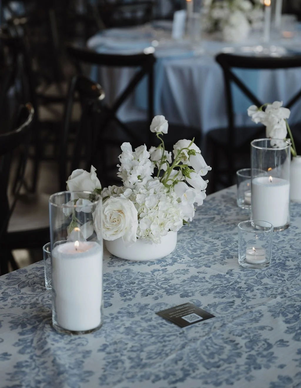 Low white arrangement beside pillar candles, florals by Hydrangea Bloom, photographed by Shelby Sawyer Photography