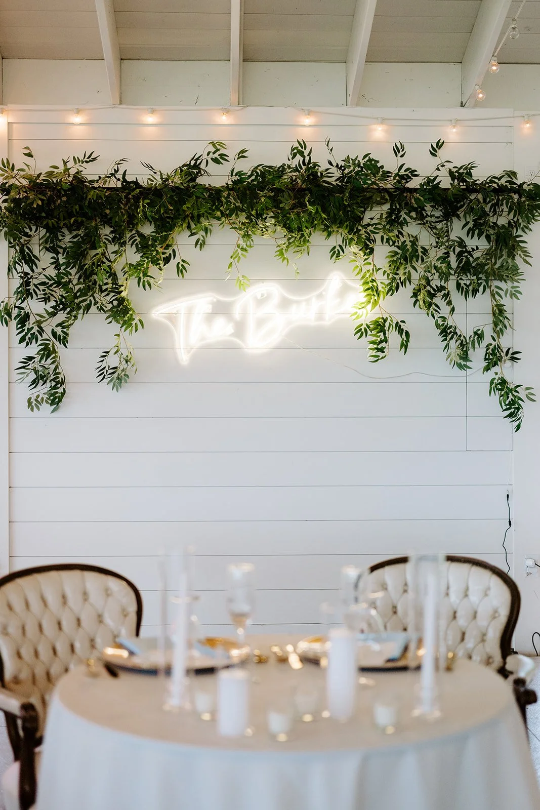 Head table greenery garland beneath a neon sign, florals by Hydrangea Bloom, photographed by Karly Ellis Photography