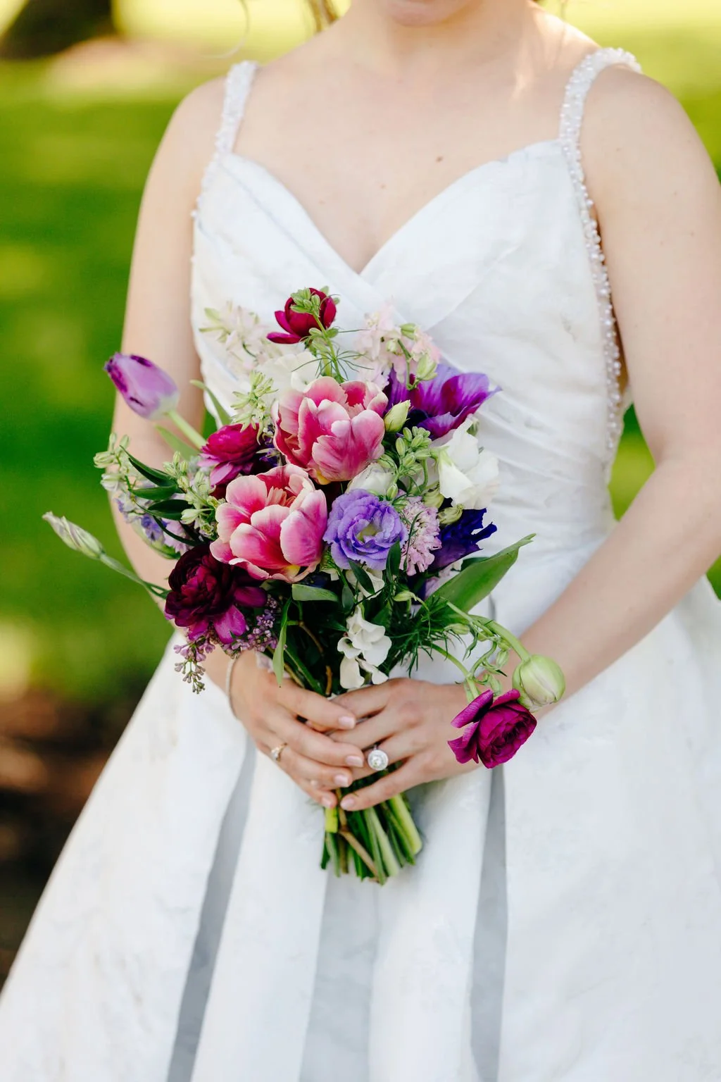Pink and purple bridal bouquet against the gown, florals by Hydrangea Bloom, photographed by Christina Ney Photography