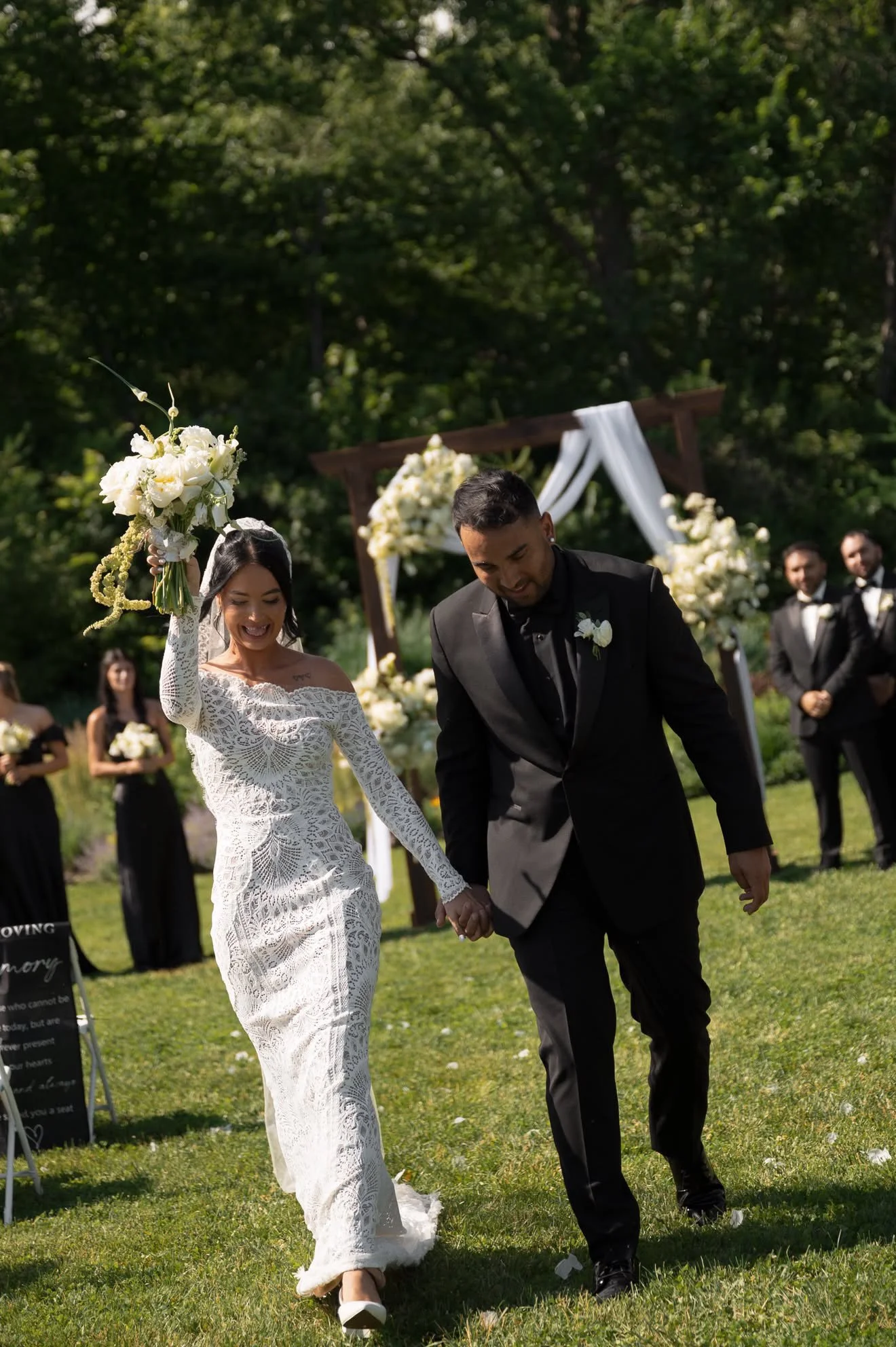 Couple walking back up the aisle, bouquet raised, florals by Hydrangea Bloom, photographed by Hayley Dolson Photography