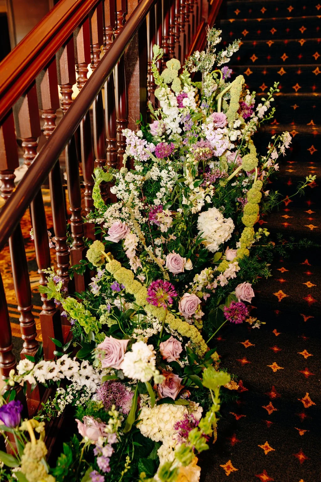 Floral garland climbing the grand staircase at Hotel Julien Dubuque, florals by Hydrangea Bloom, photographed by Christina Ney Photography