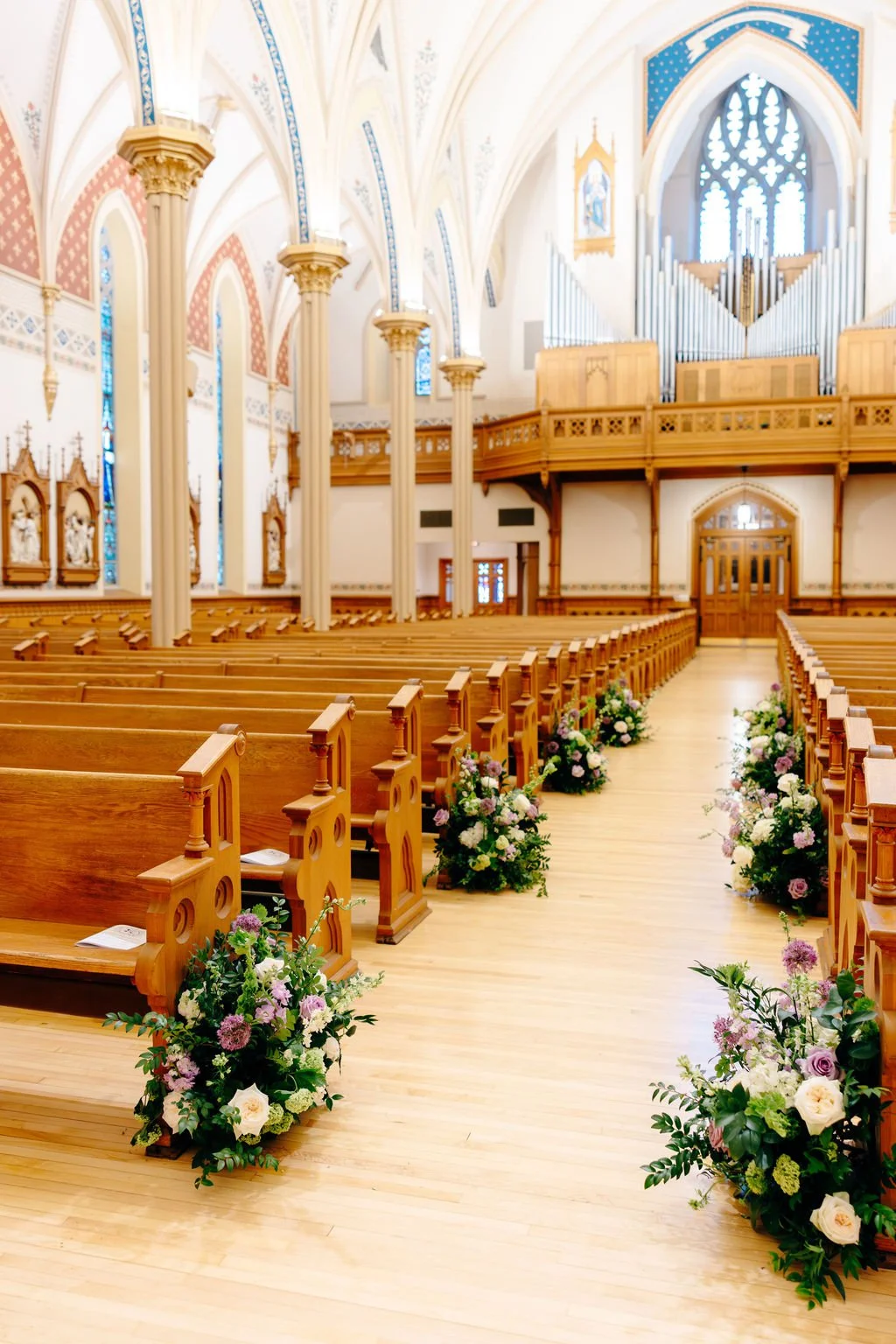 Cathedral aisle lined with floral arrangements, florals by Hydrangea Bloom, photographed by Christina Ney Photography