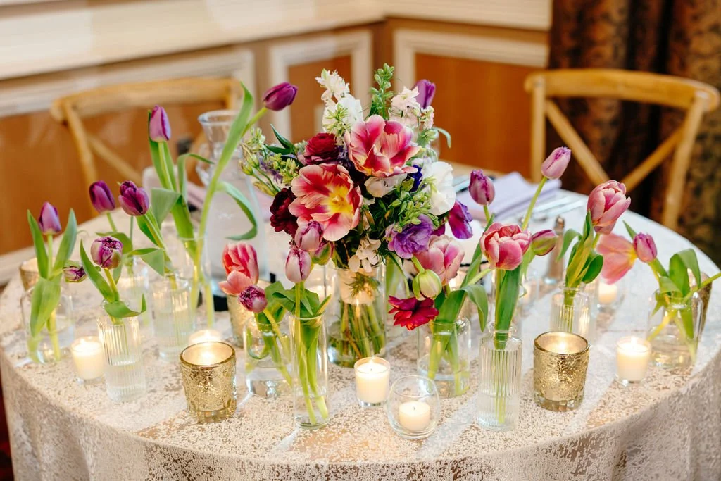 Low tulip arrangements and bud vases along the table, florals by Hydrangea Bloom, photographed by Christina Ney Photography