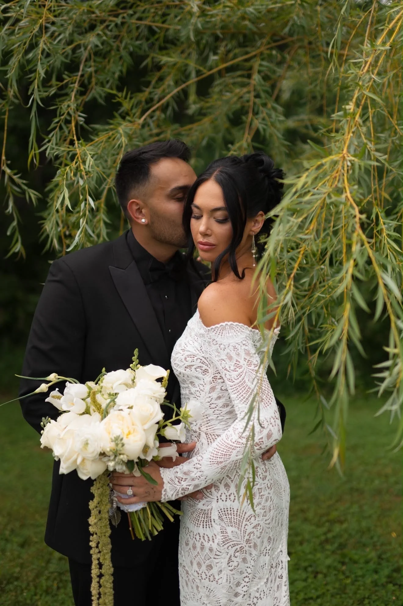 Couple embracing beneath the willow with the bouquet, florals by Hydrangea Bloom, photographed by Hayley Dolson Photography