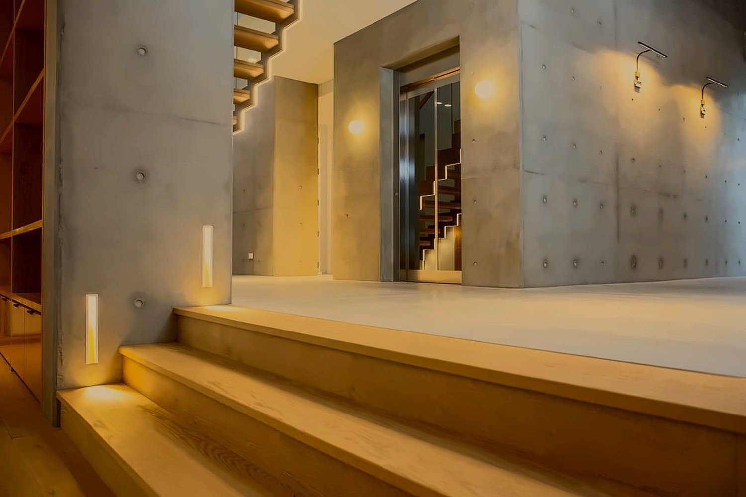 Off-form concrete, oak steps and lit stairwell in a private Sydney home