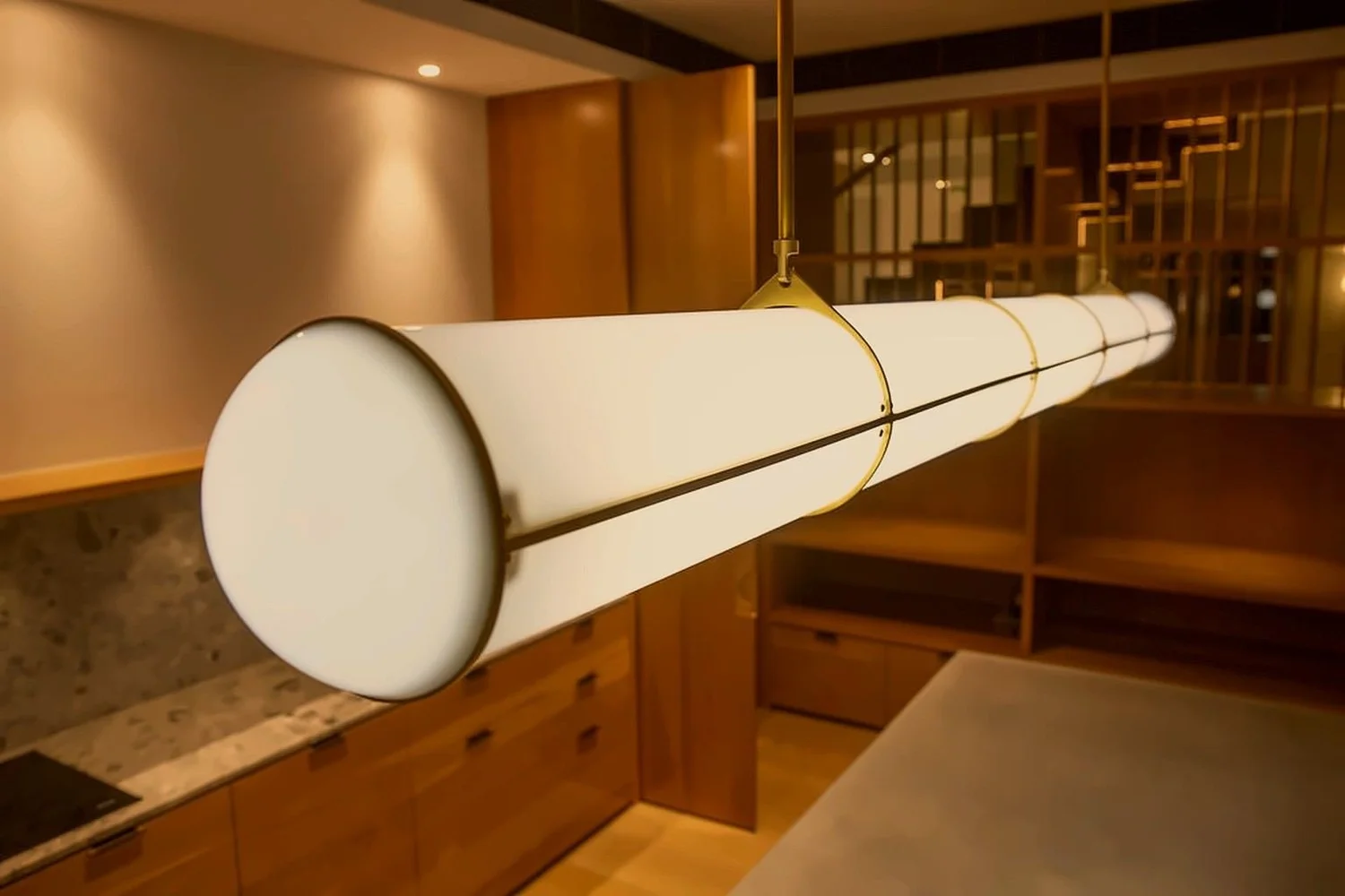 Brass and opal pendant light above a stone kitchen