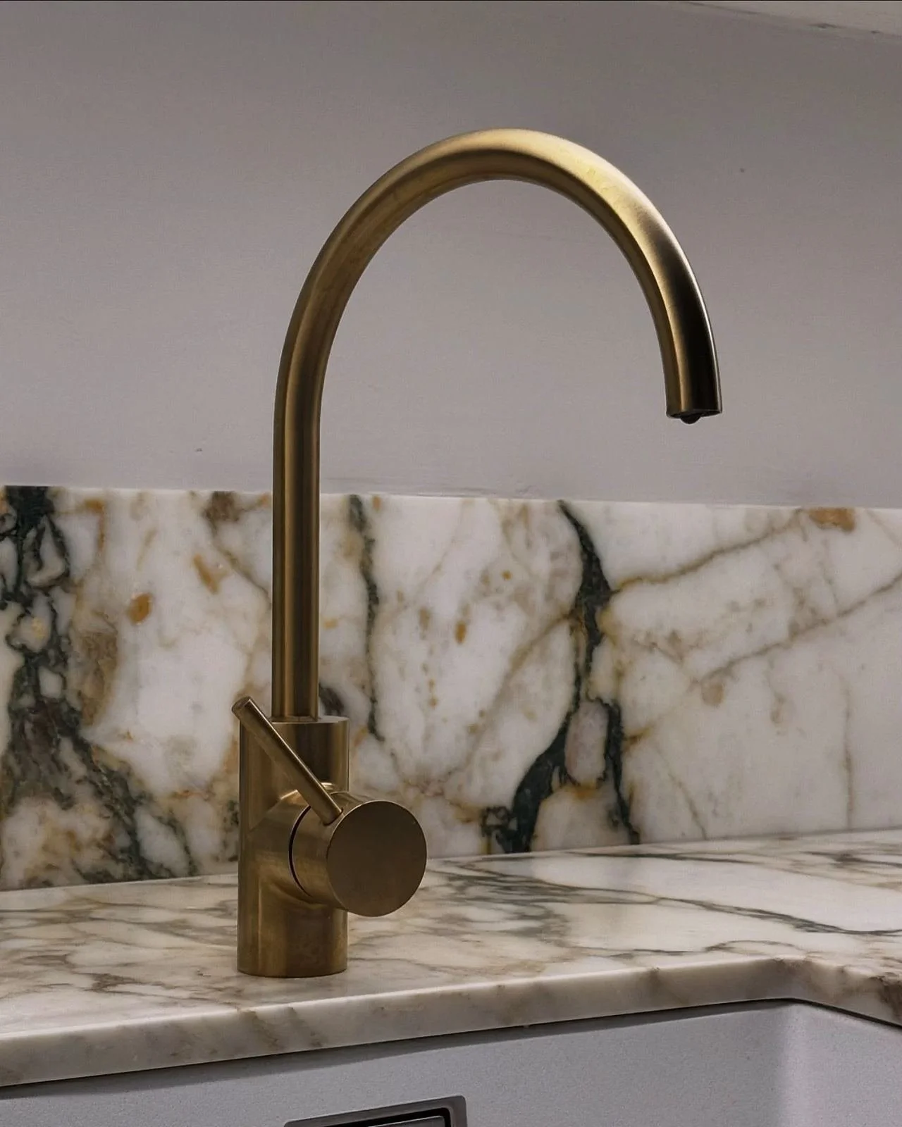 Brushed brass tapware on a veined marble benchtop, Potts Point