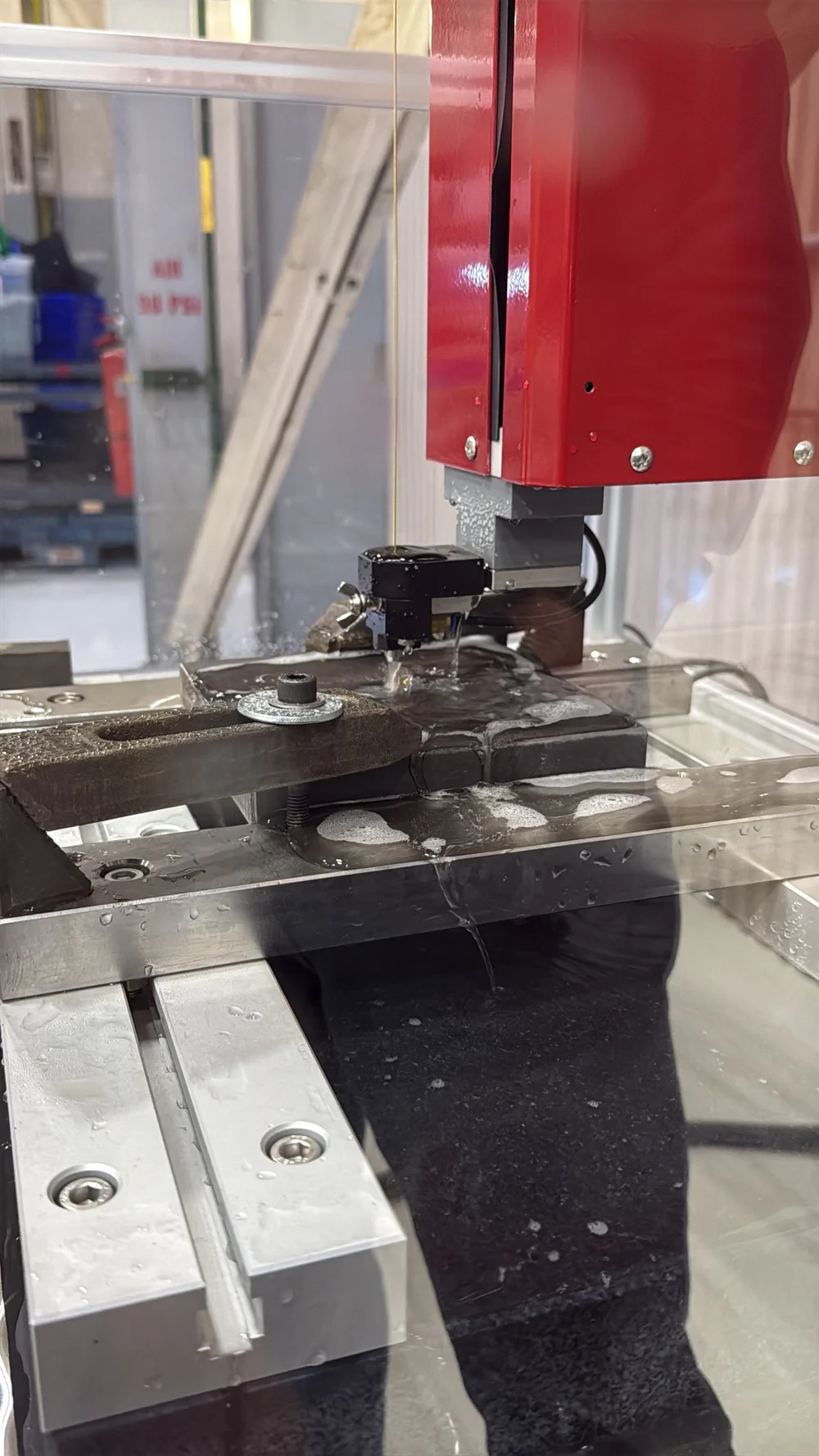 EDM hole drilling electrode positioned over a machined part at UTP Solutions