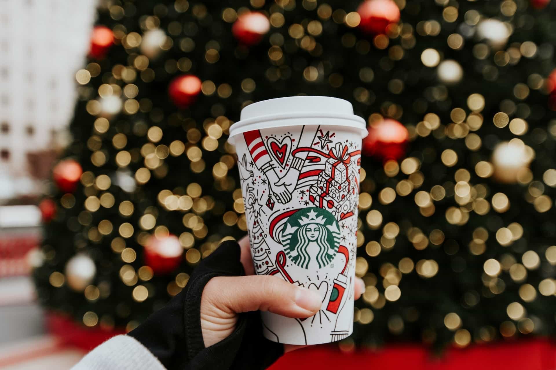 Starbucks' green identity to emphasize its connection to nature as seen on a mug in front of a christmas tree