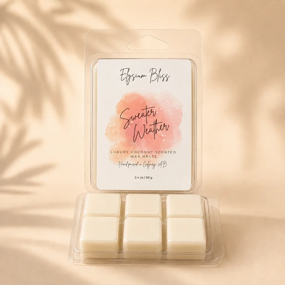 Open clamshell of Elysium Bliss Sweater Weather coconut wax melts showing six cream-coloured cubes, on a warm cream background with soft palm-frond shadow.
