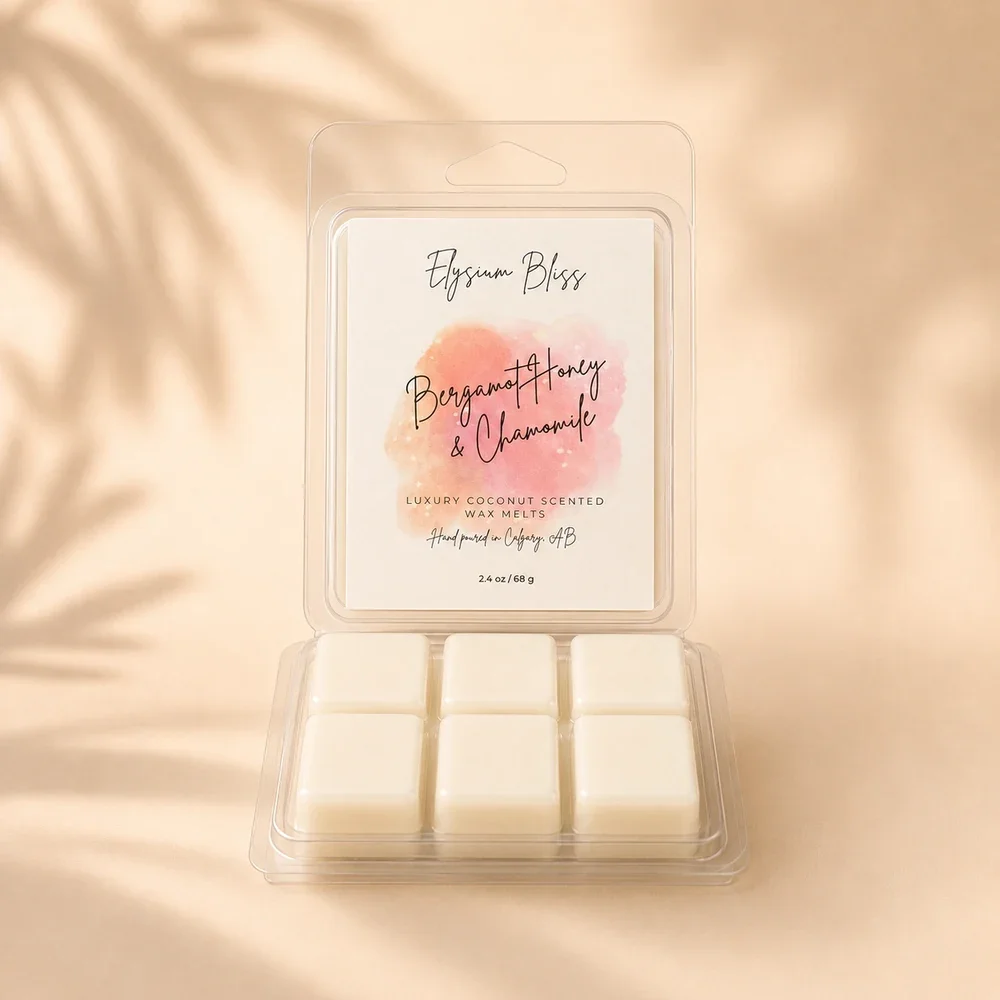 Open clamshell of Elysium Bliss Bergamot Honey & Chamomile coconut wax melts showing six cream-coloured cubes, on a warm cream background with soft palm-frond shadow.