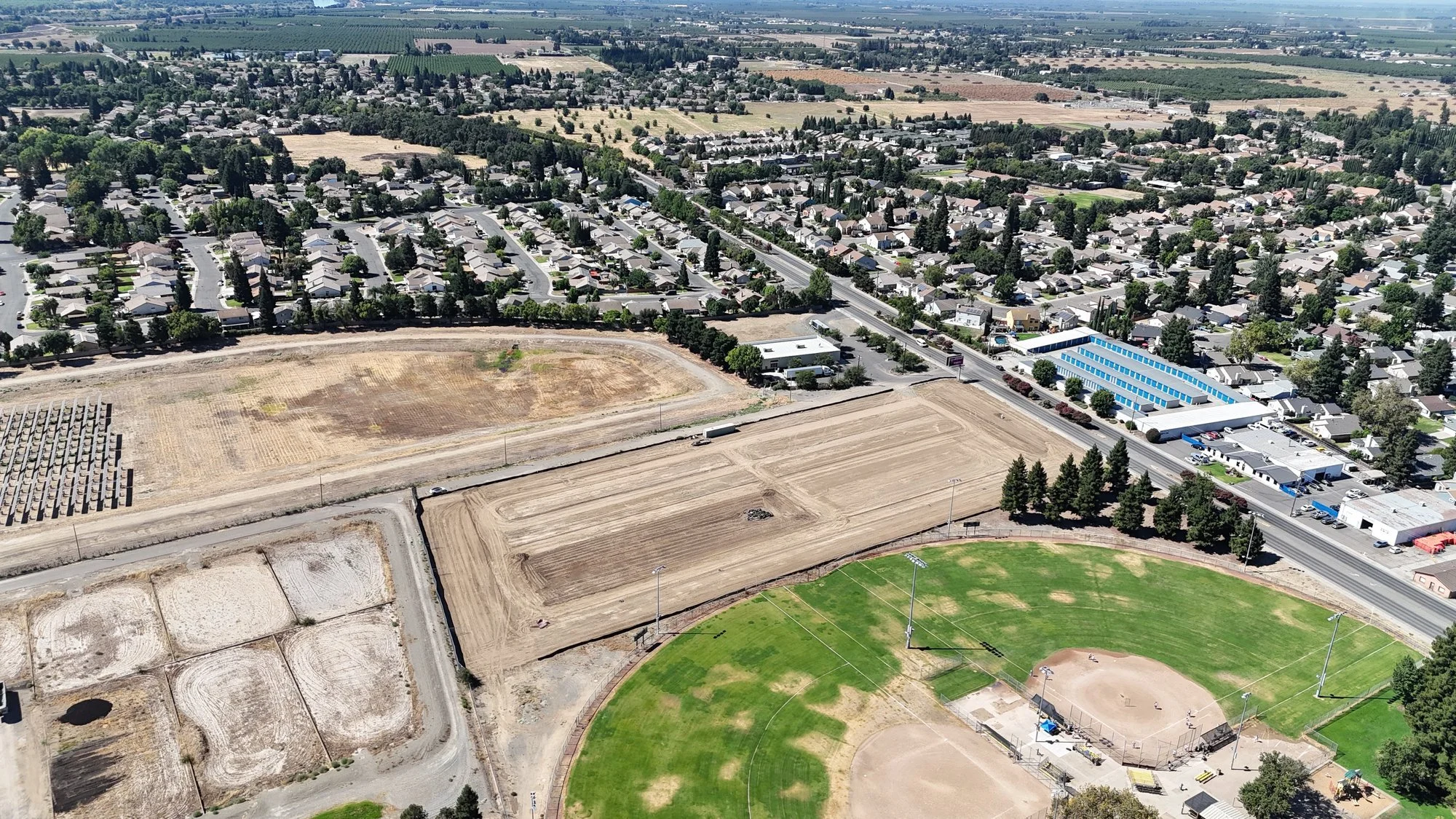 Aerial view of a graded five-acre self-storage site under construction in Yuba City, California
