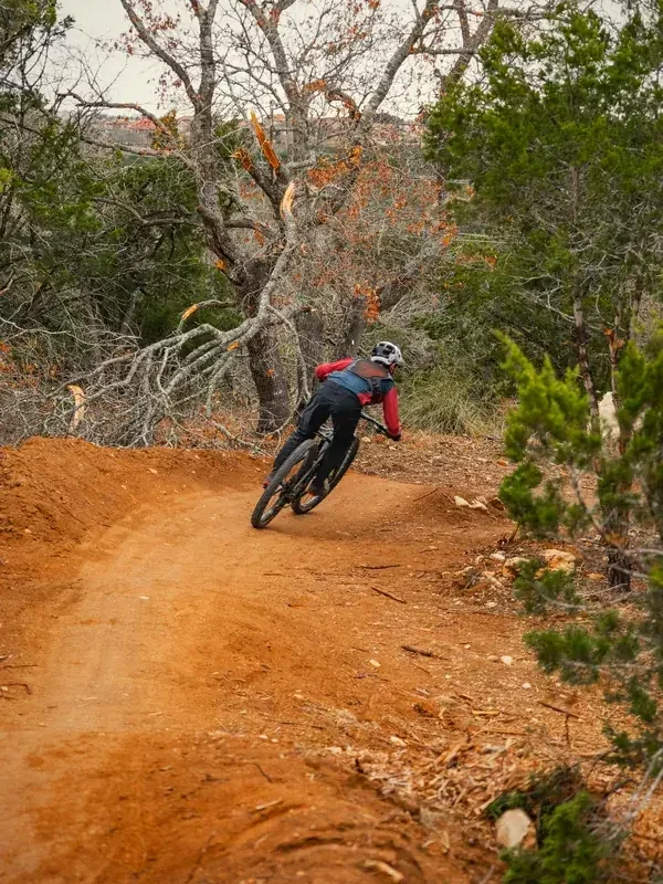 Rider leaning into a red-dirt berm
