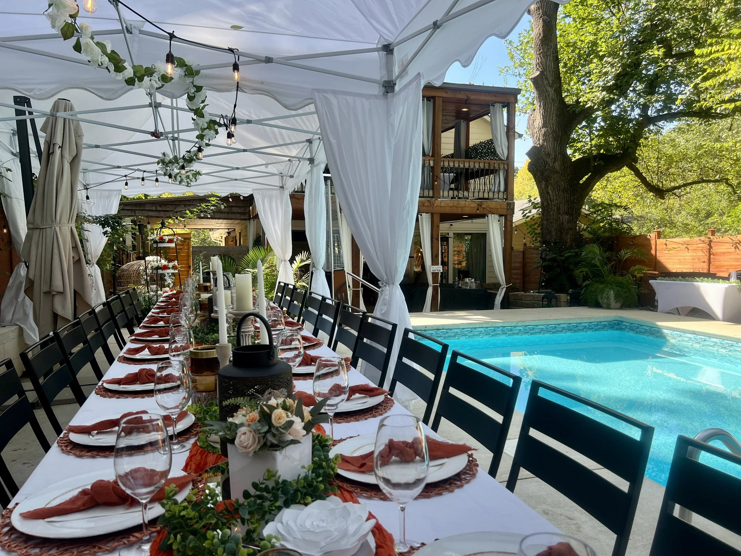 Long tented table set poolside at golden hour
