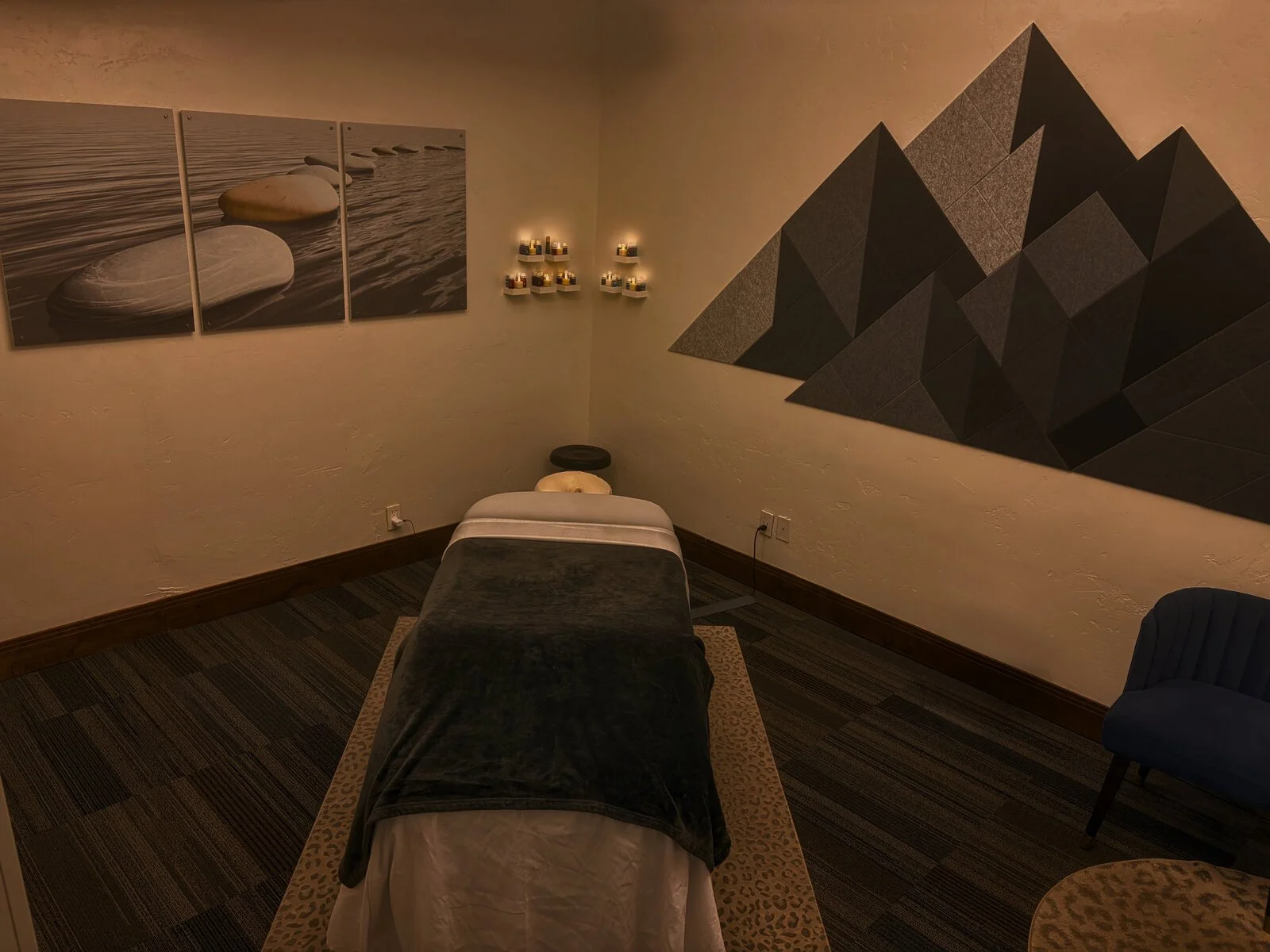 A treatment room at Halo Massage in Park City, with a massage table and calming mountain-themed decor in warm low light