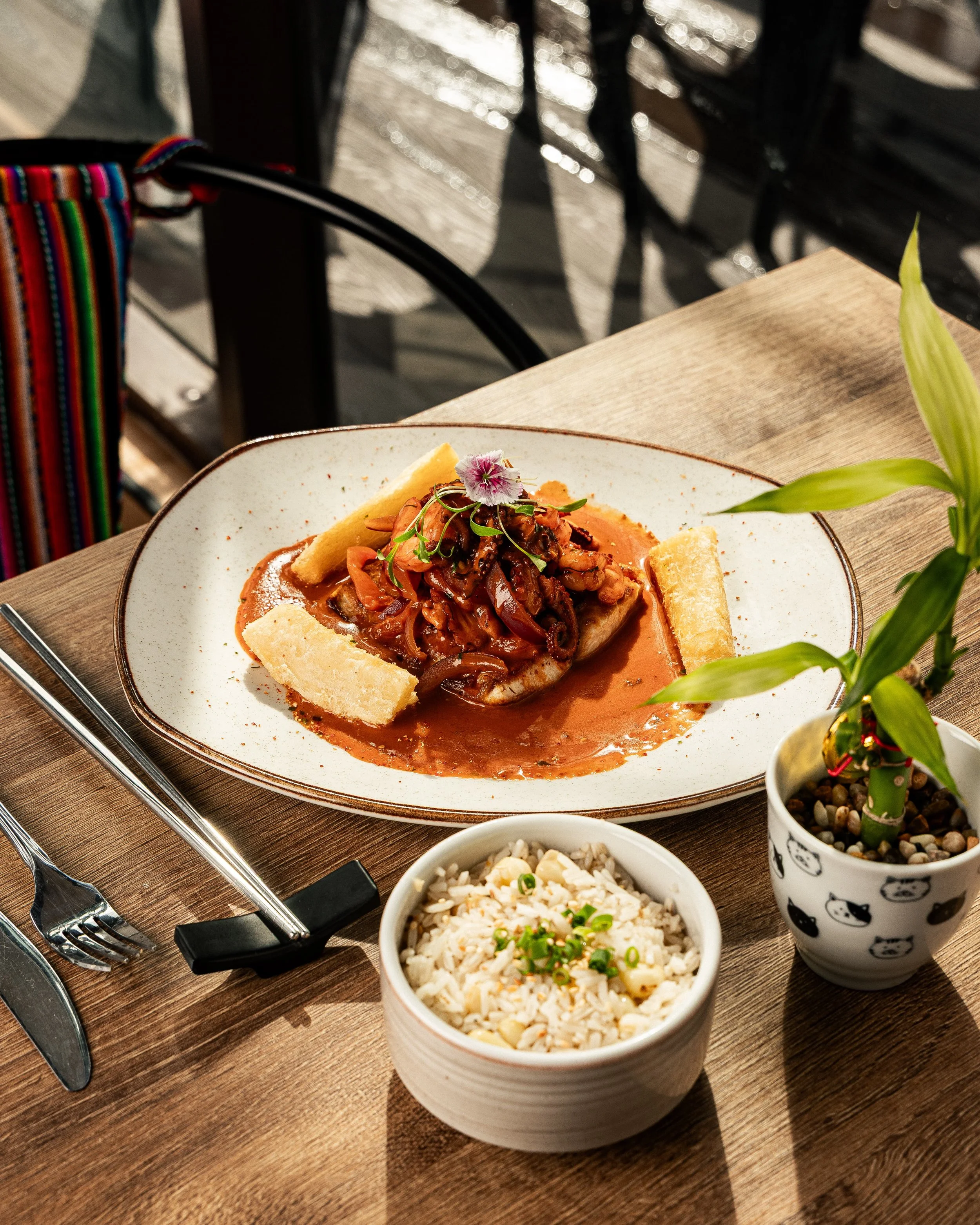 Enkai main course in red sauce served with white rice on a wooden table.