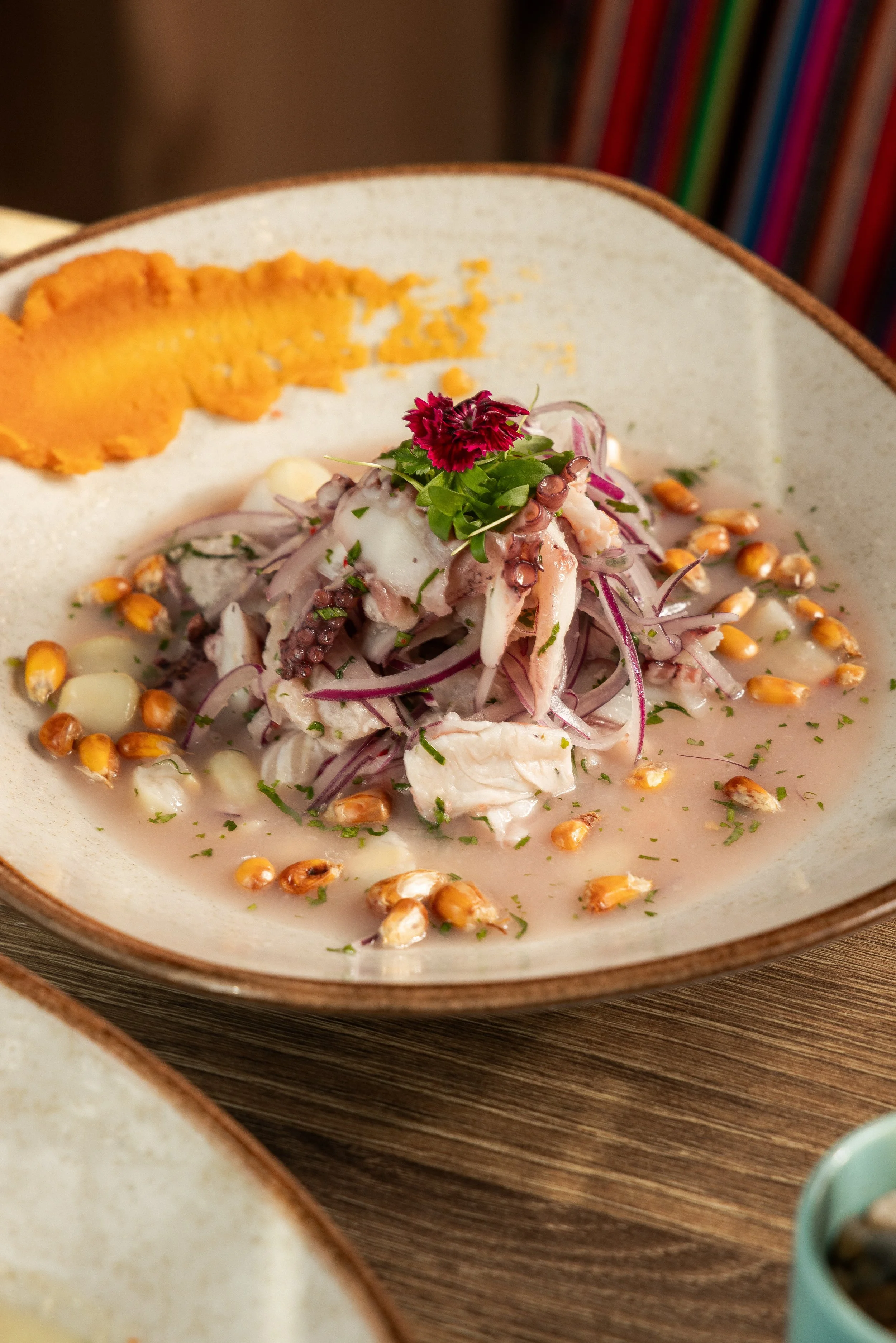 Ceviche-style fish with red onion, corn and edible flowers at Enkai.