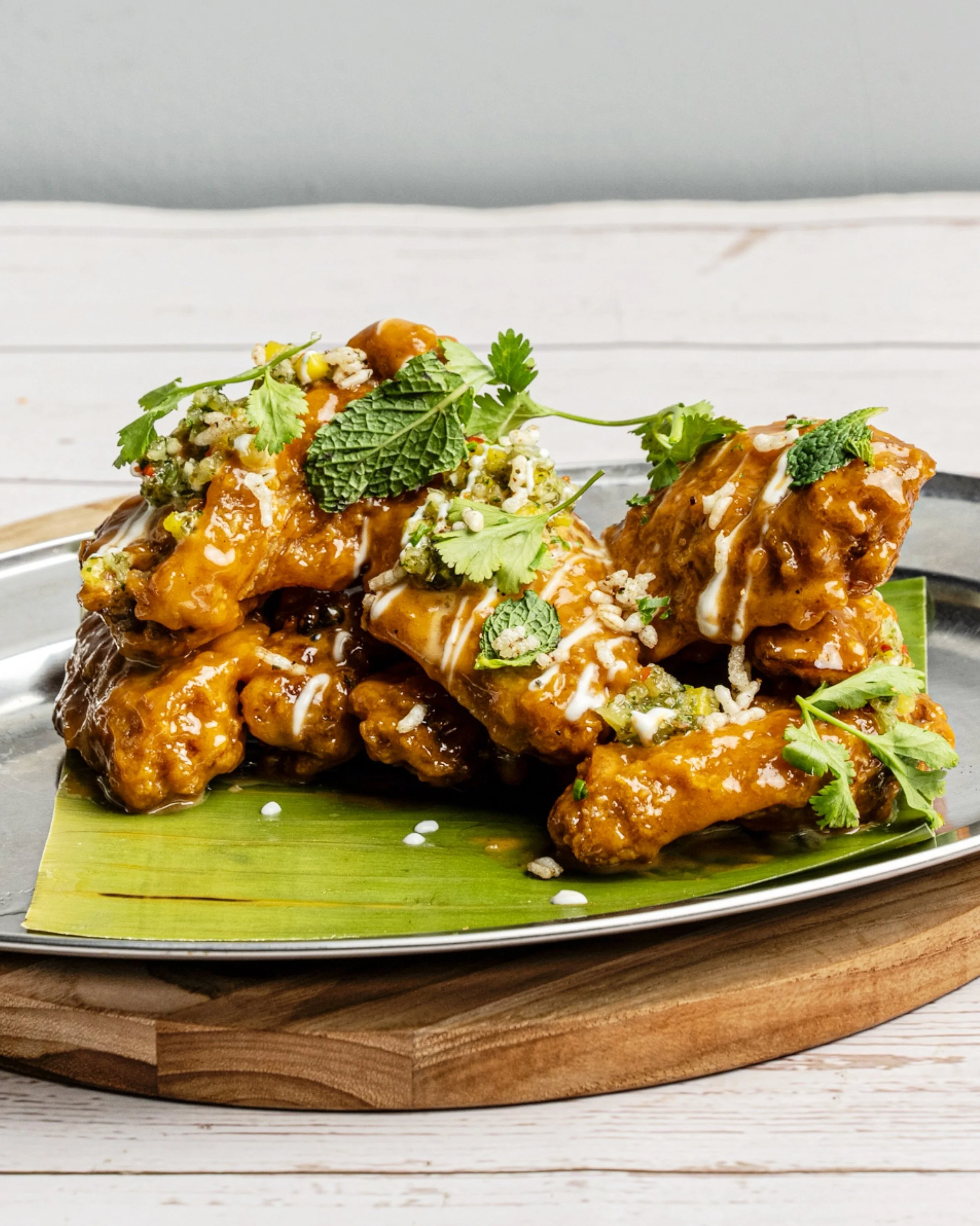 Golden glazed chicken wings with herbs at La Tapa del Coco